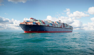 3d cargo container ship in ocean. Large cargo vessel loaded with containers sailing in sea.